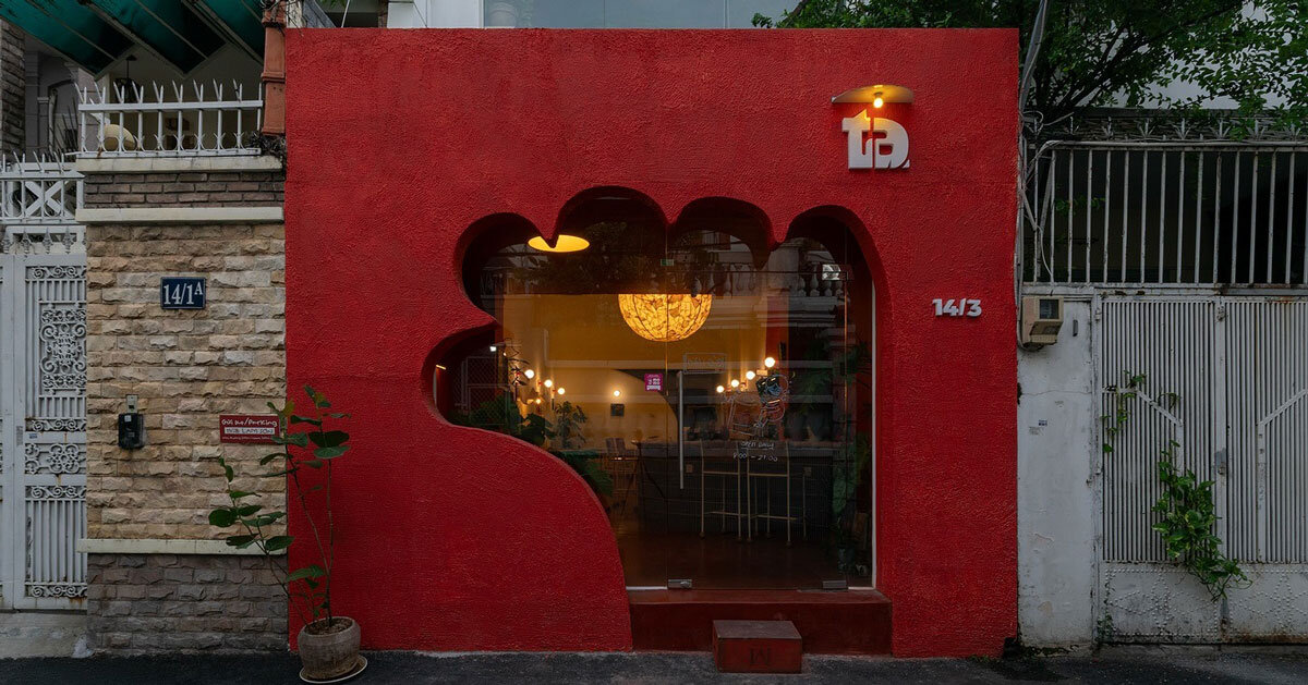 café’s red facade carves hand-shaped entrance in vietnam