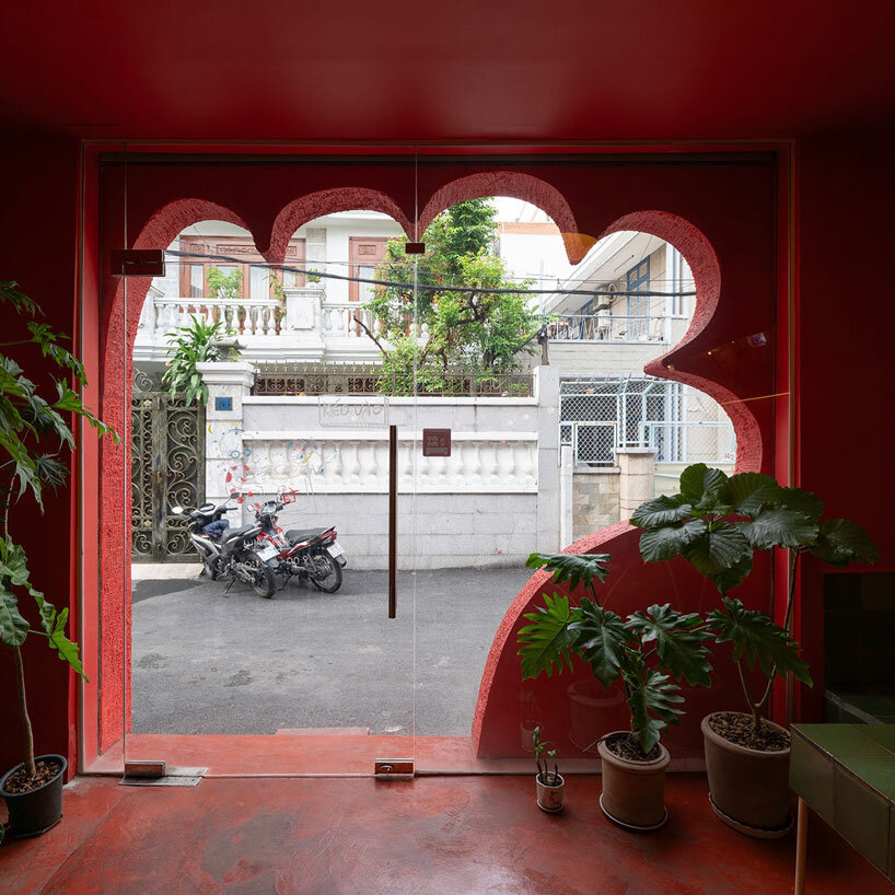 café’s red facade carves welcoming hand-shaped entrance in vietnam