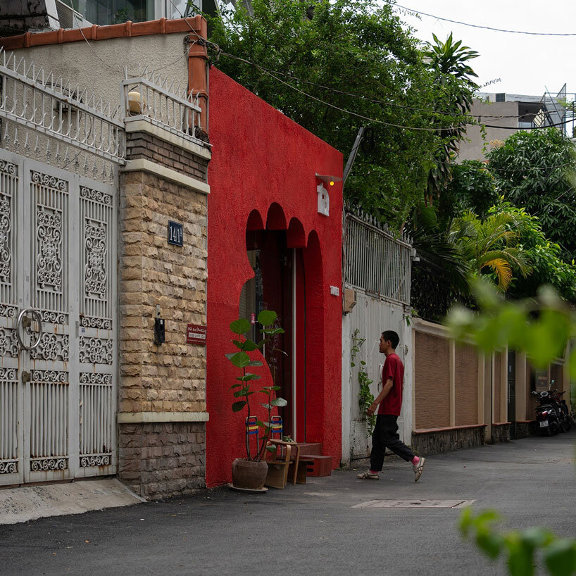 café’s red facade carves welcoming hand-shaped entrance in vietnam