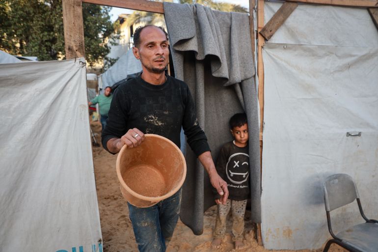 A man holds an empty bucket