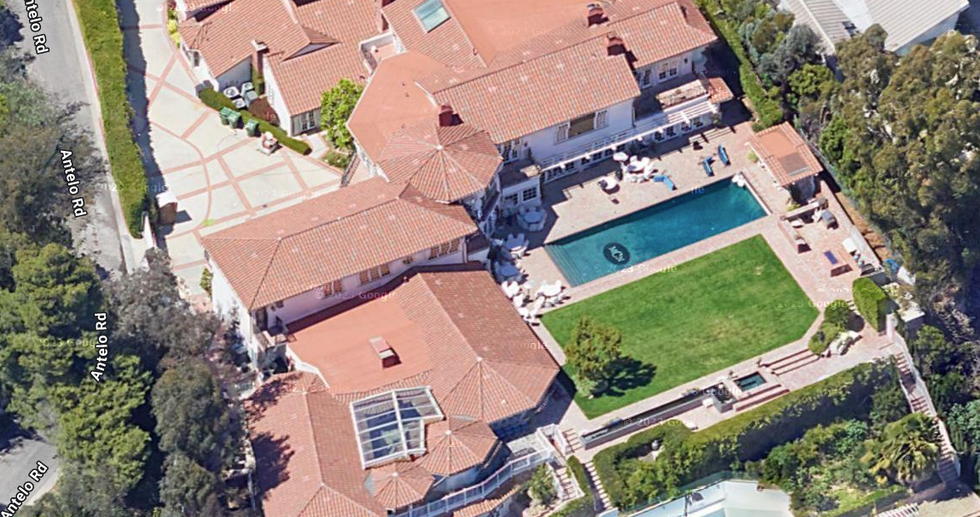 Aerial view of a luxury home with a pool and landscaped yard.