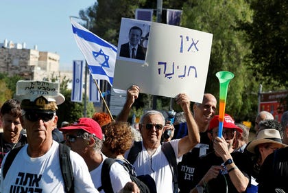 A demonstrator holds a sign showing President Isaac Herzog with the words "No pardon" in Jerusalem, December.
