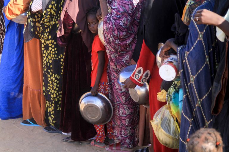 A Sudanese girl who fled El-Fasher lines up with other women to receive a free meal at the Al-Afad camp for displaced people in the town of Al-Dabba, northern Sudan, on November 20, 2025.