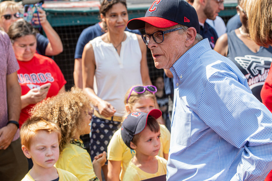 FILE - Ohio Gov. Mike DeWine, right, waits to hand out reading certificates to children before a Cleveland Guardians baseball game against the Minnesota Twins in Cleveland, Sunday, Sept. 18, 2022. (AP Photo/Phil Long, File)