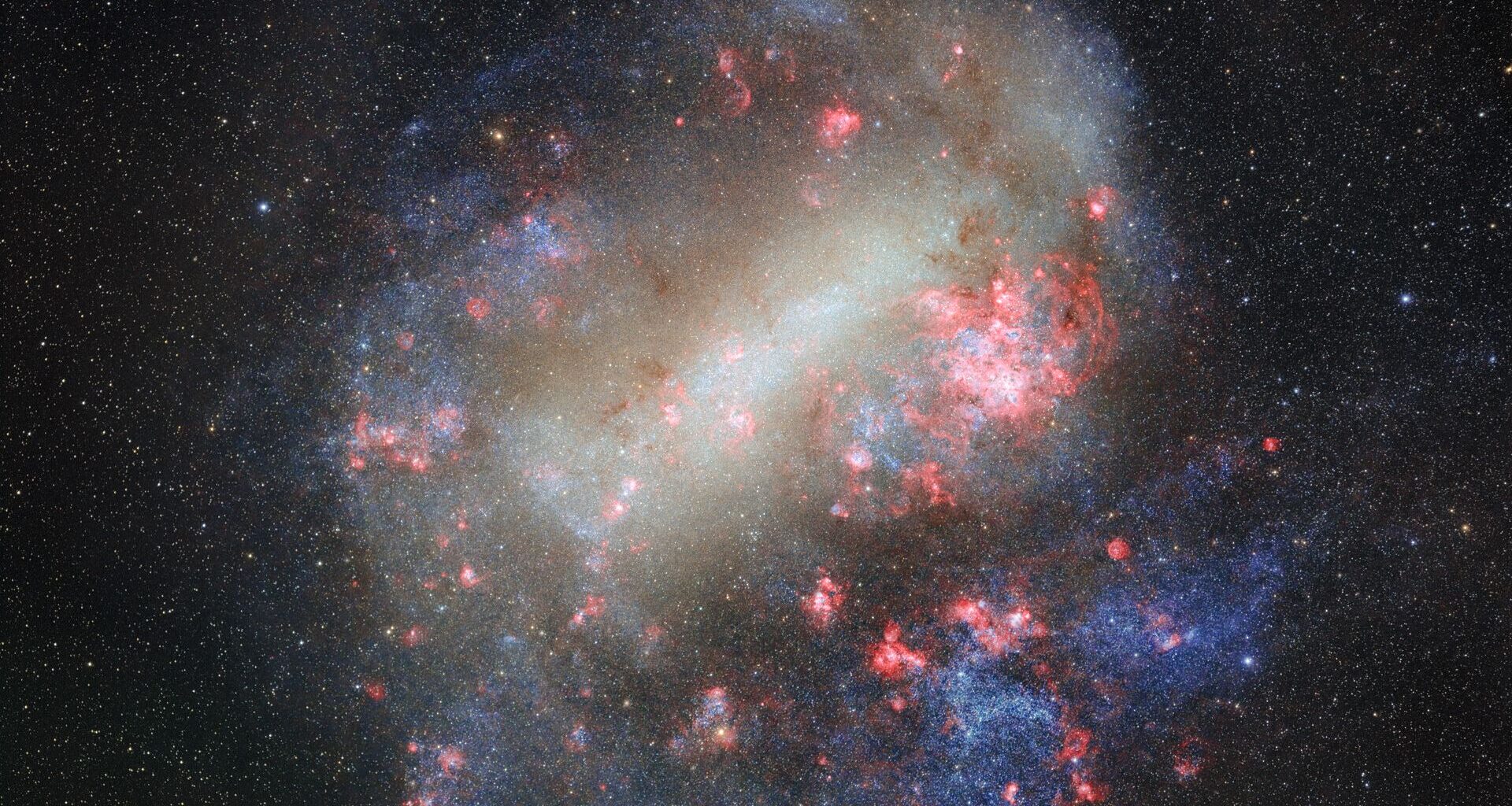Swirls of white, purple and pink colors flow among bright dots for stars in the Large Magellanic Cloud as seen in space