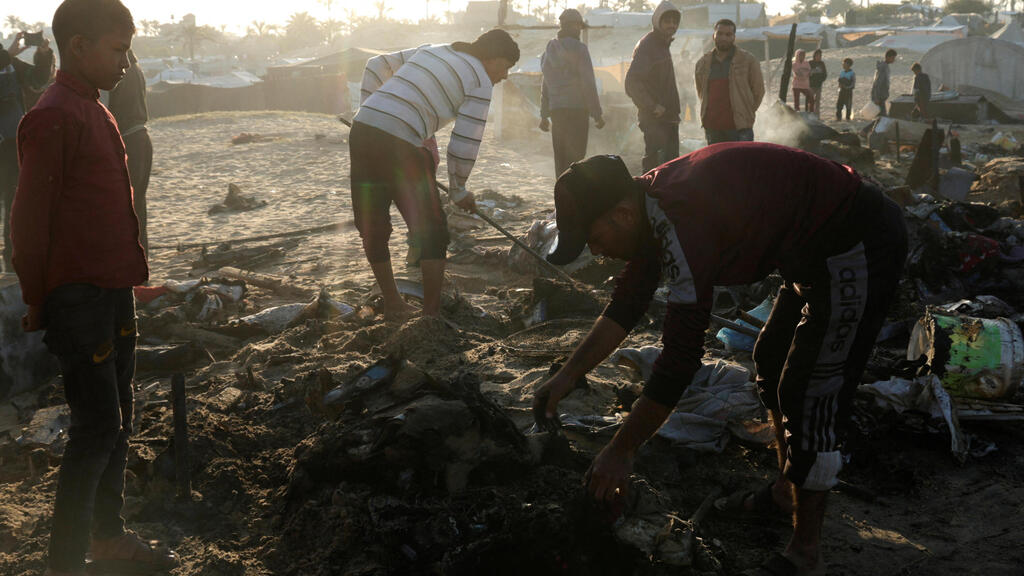The destruction in Khan Younis in Gaza (Photo: Hatem Khaled/Reuters) עזתים בודקים נזק באתר בו תקפה ישראל בחאן יונס
