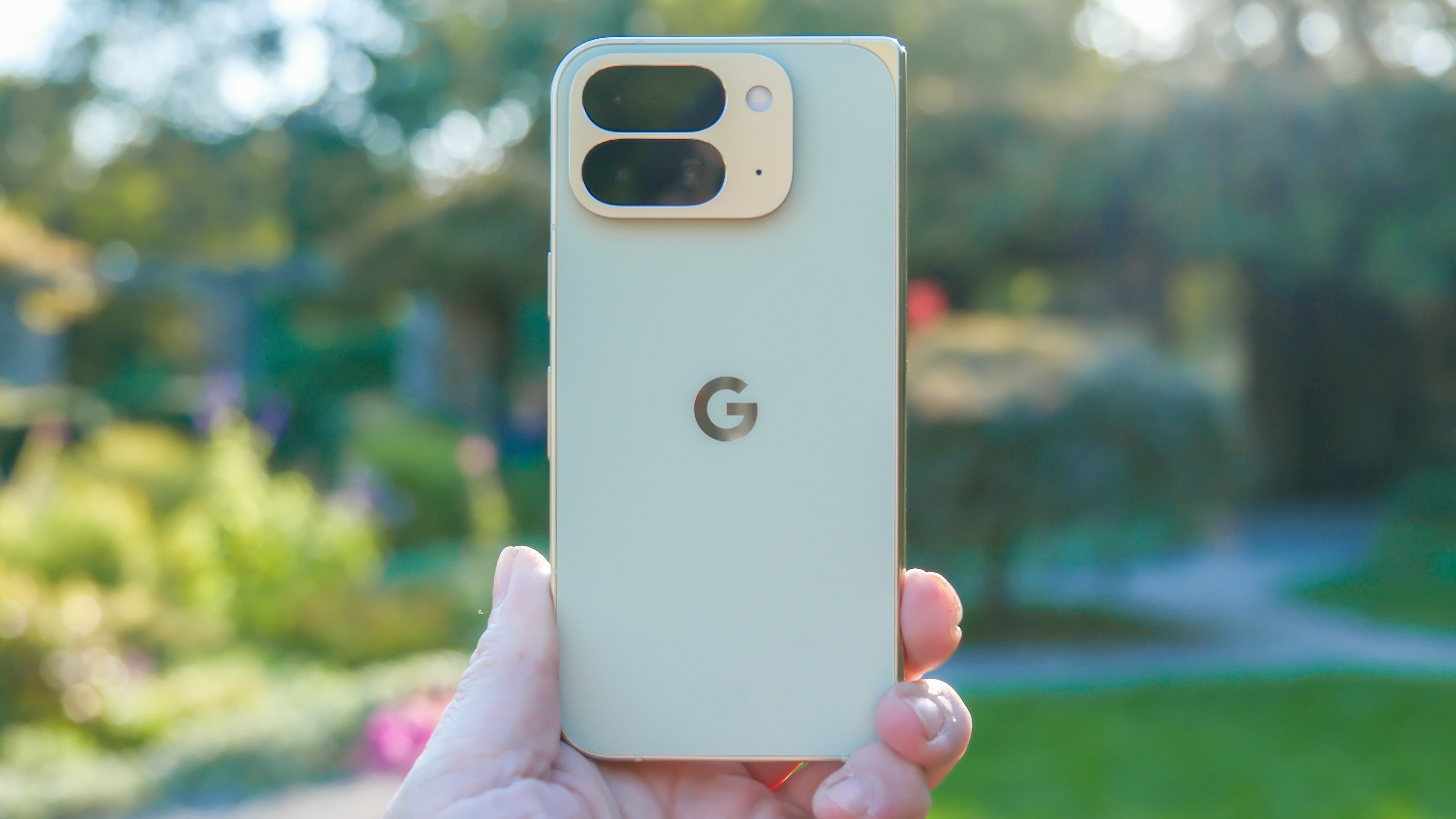 Google Pixel 10 Pro Fold in Jade green outside at a flower garden on a sunny day