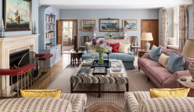 traditional powder blue living room with eclectic English style, a fireplace, upholstered ottoman and mismatched patterned sofas and armchairs
