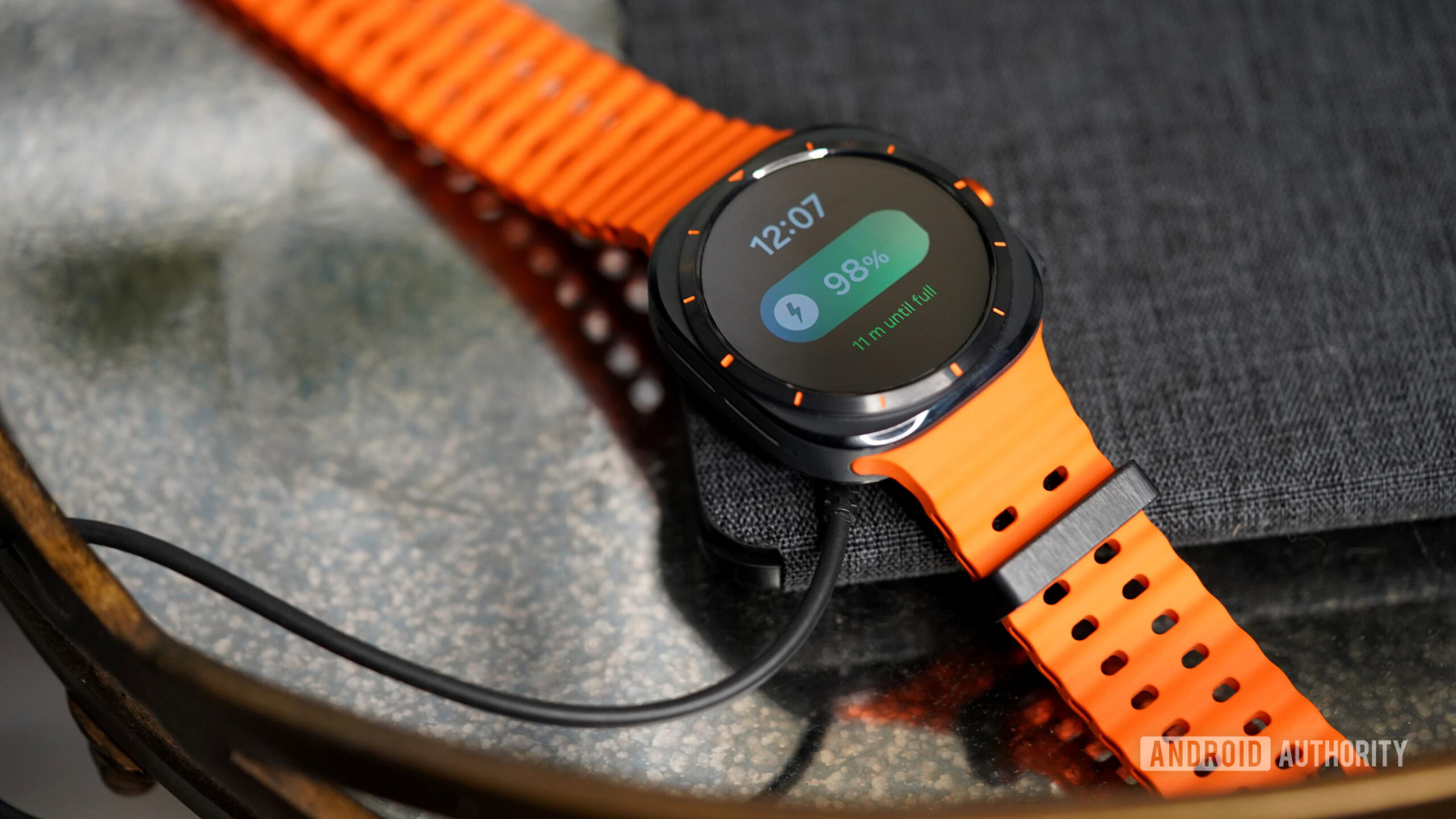 Galaxy Watch Ultra Charging A Galaxy Watch Ultra rests on its charger.