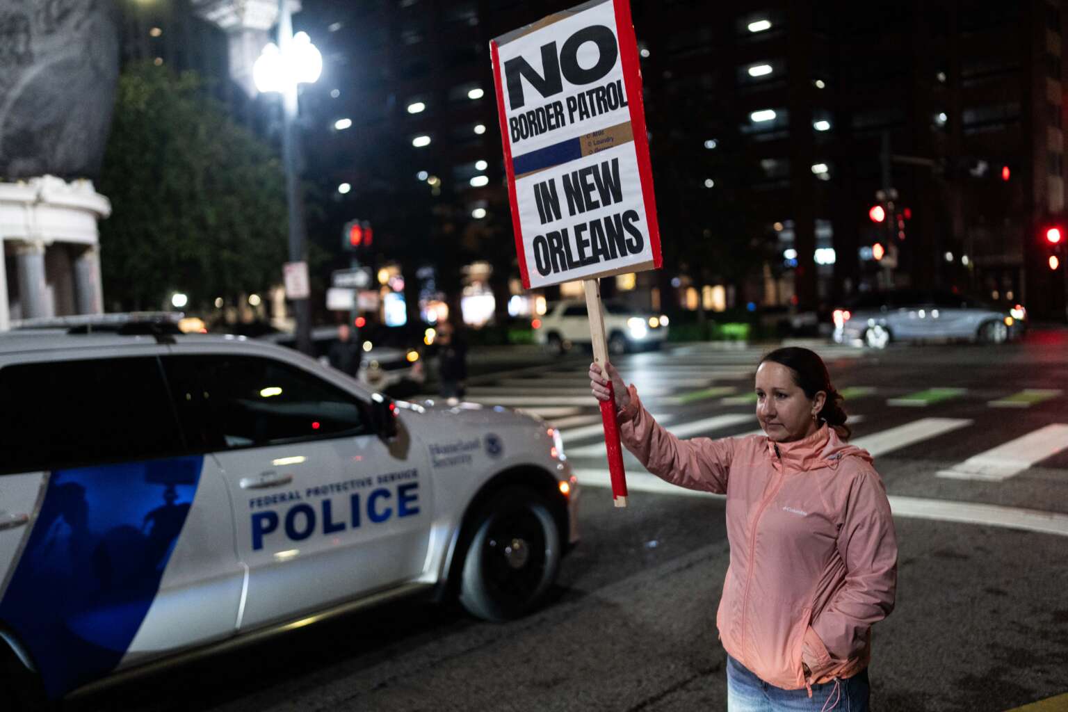 A woman holds a sign during a protest against the U.S. Border Patrol and Immigration and Customs Enforcement (ICE) outside of Hale Boggs Federal Building in New Orleans, Louisiana, on December 6, 2025.