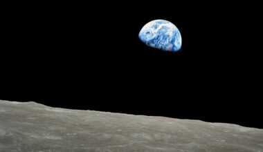 A photo of the Earth in the darkness of space with the surface of the moon in the foreground of the image