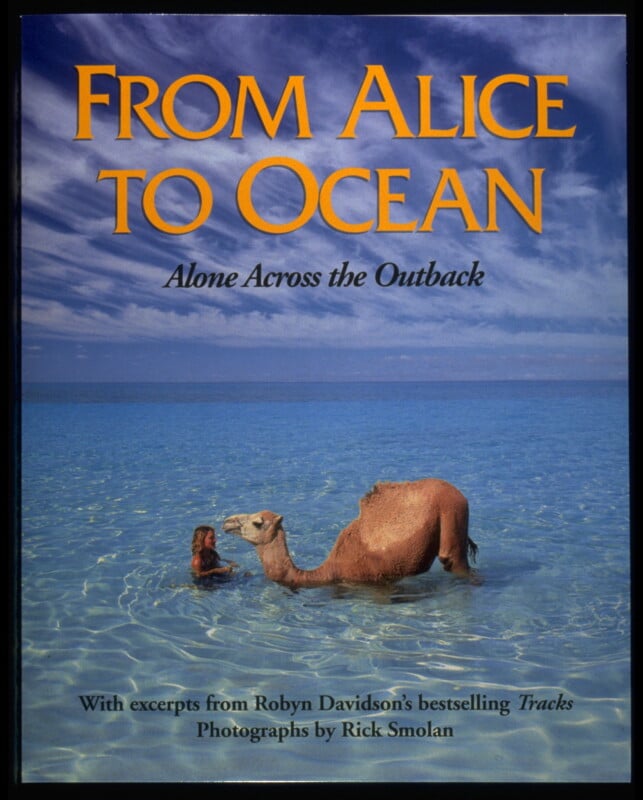 Book cover of "From Alice to Ocean: Alone Across the Outback," showing a woman and a camel in clear blue water under a bright sky. Text highlights excerpts from Robyn Davidson’s "Tracks" and photos by Rick Smolan.