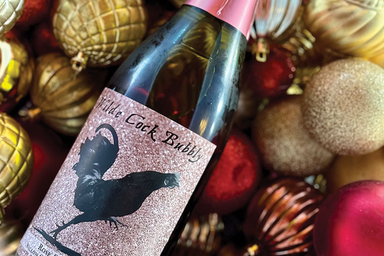 Bottle of wine amid Christmas ornaments