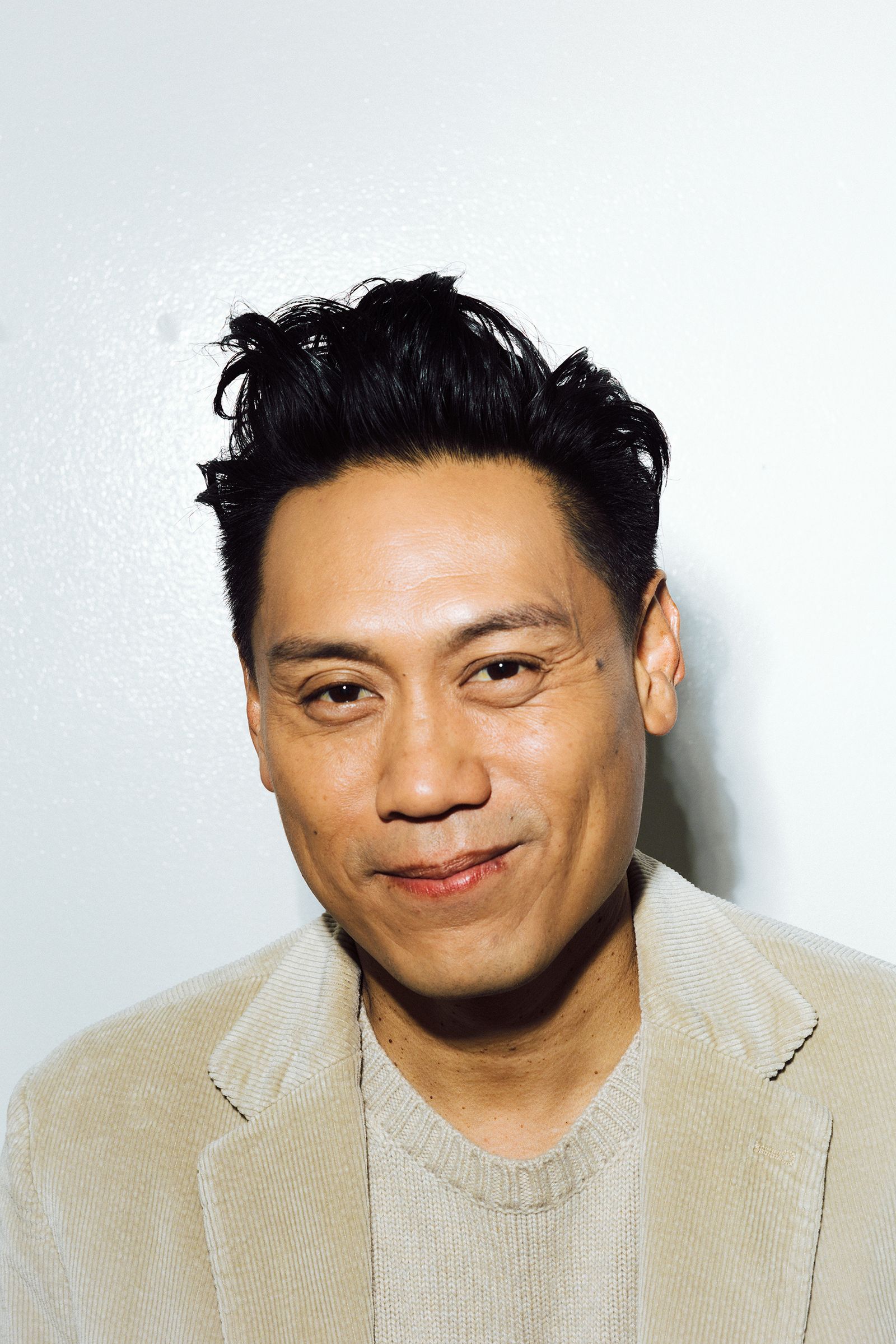 Image may contain Jon M. Chu Dimples Face Head Person Happy Smile Adult Black Hair Hair Body Part and Neck