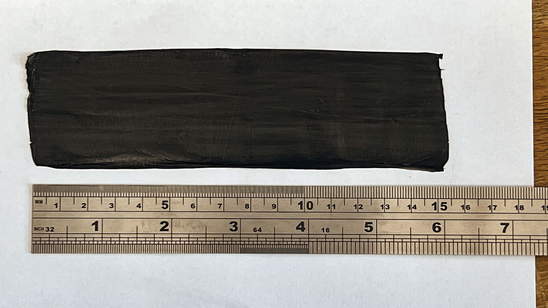 Photograph of a mat of carbon nanotubes and a ruler for scale.