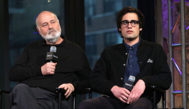 Rob Reiner and Nick Reiner sitting on a stage, both holding microphones.