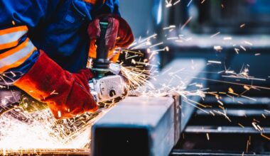 Sparks flying around a person working on a machine in an industrial setting.