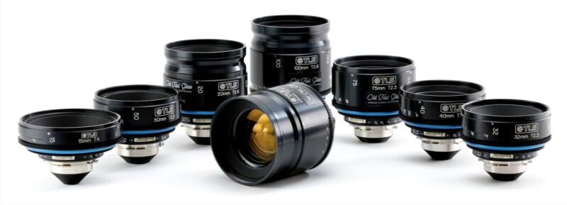A set of nine black camera lenses with blue accents, arranged in a semi-circle on a white background, with one lens lying in the front and the others standing upright behind it.