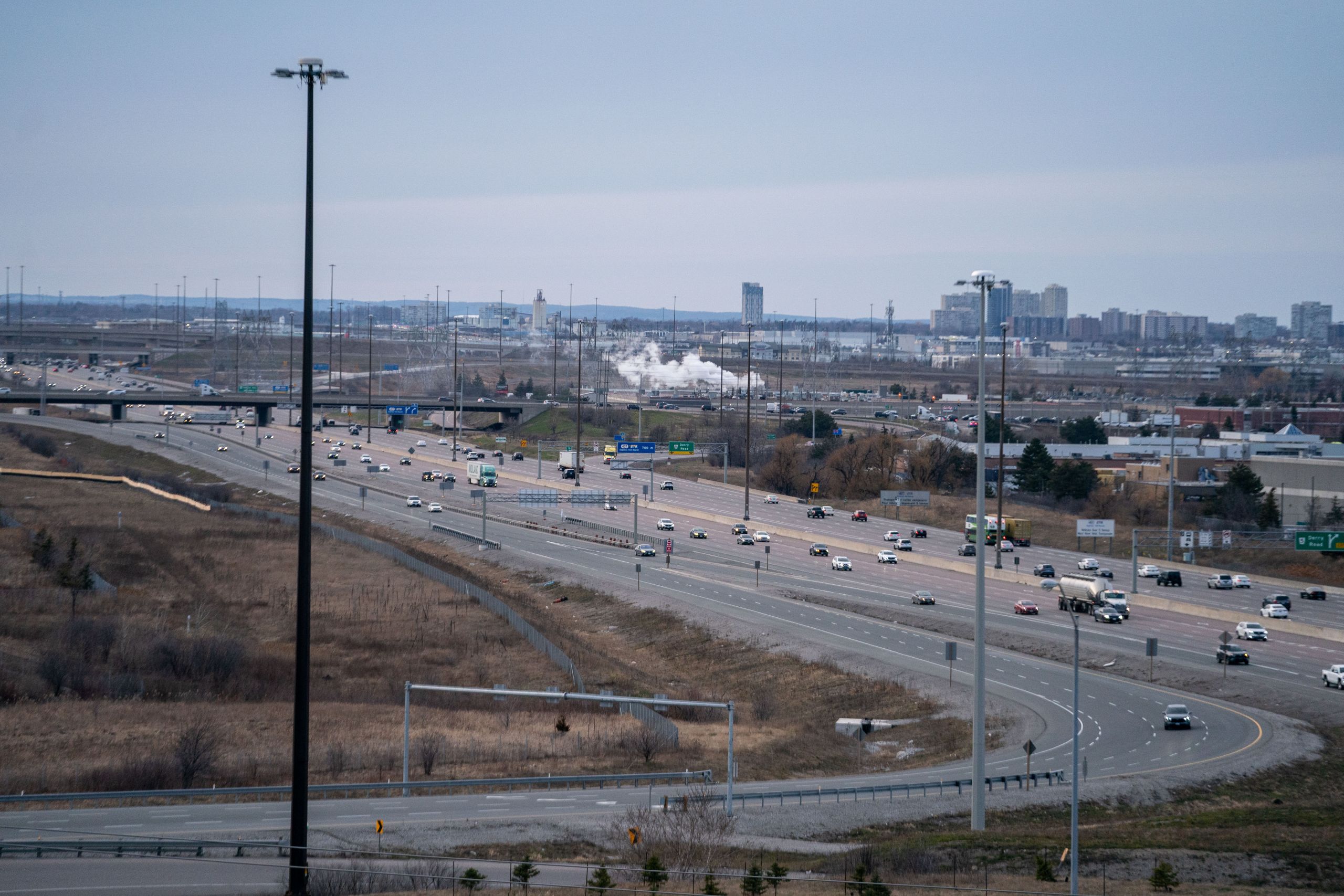 A highway with industrial activity in the background.