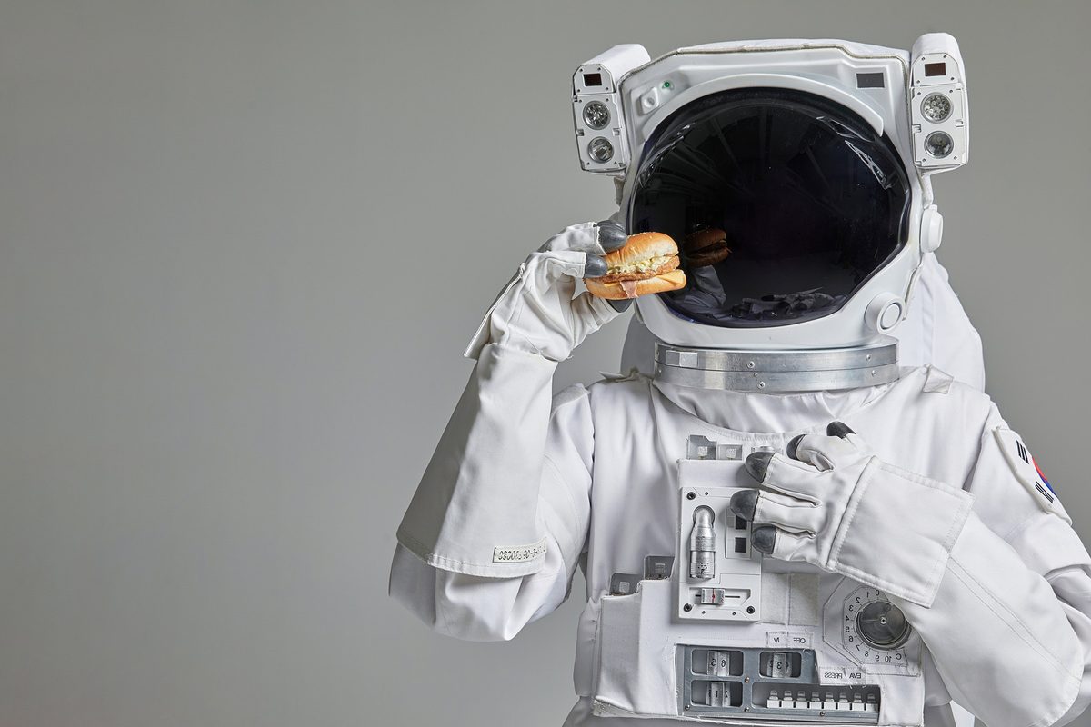 Astronaut holding up a burger