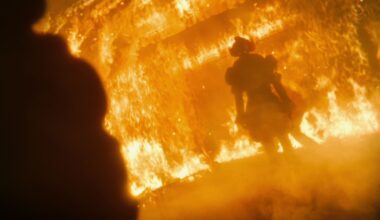 Bill Skarsgard as Pennywise standing in a burning building in It: Welcome to Derry