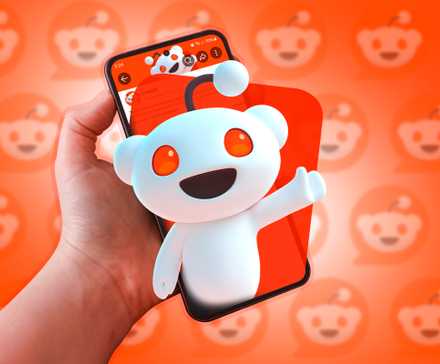 A phone with the Reddit mascot coming out of the screen.