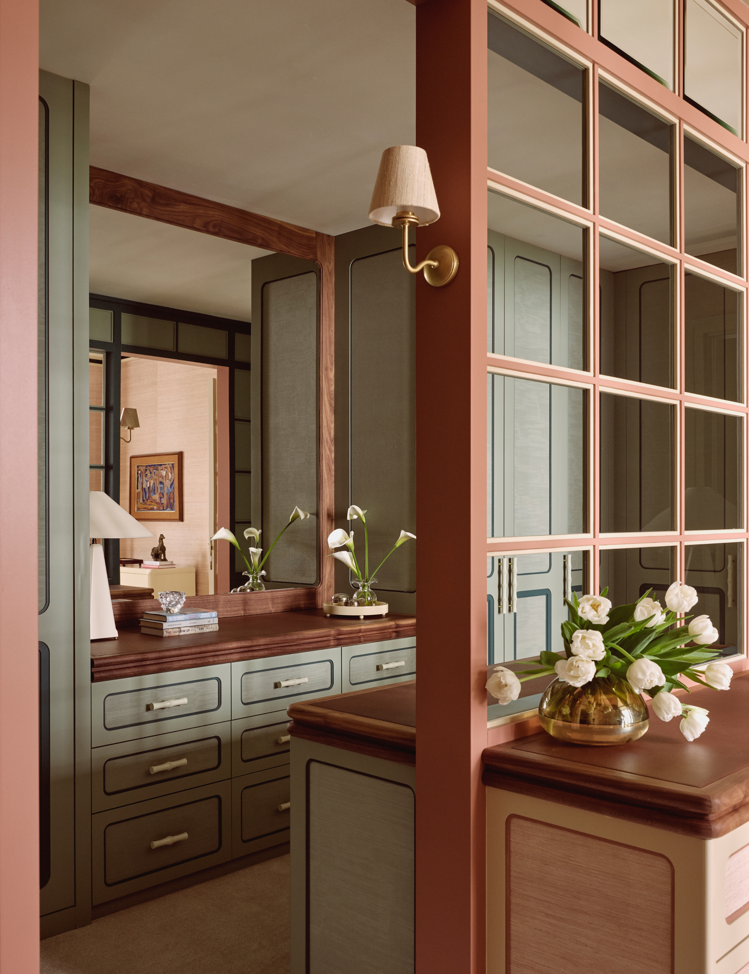 Neutral brown-and-moss dressing area featuring built-in drawers and collected objects from the vantage of a windowpane divider grid