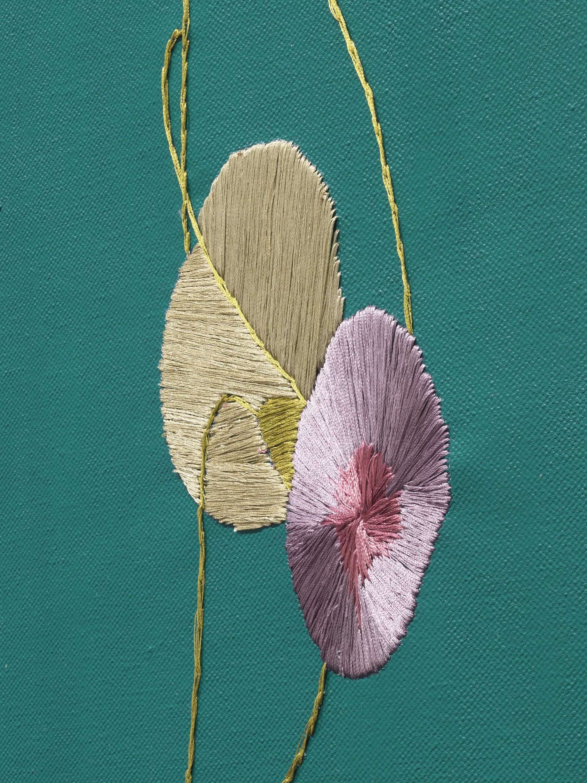 An embroidered detail on teal-painted canvas
