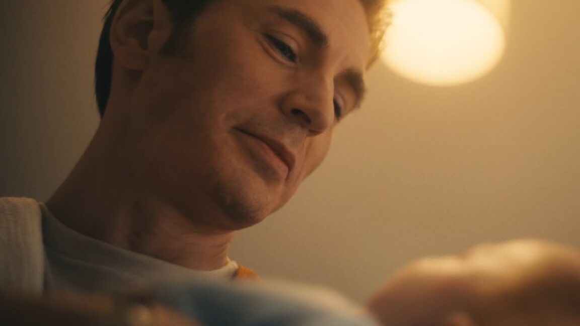 handsome blond man looking down a newborn baby with love