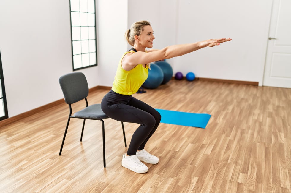 5 minute home workout: woman moving to recline into a chair.