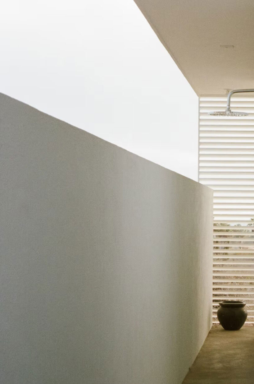 white louvers craft perforated facade filtering daylight within casa nada’s interiors in mexico