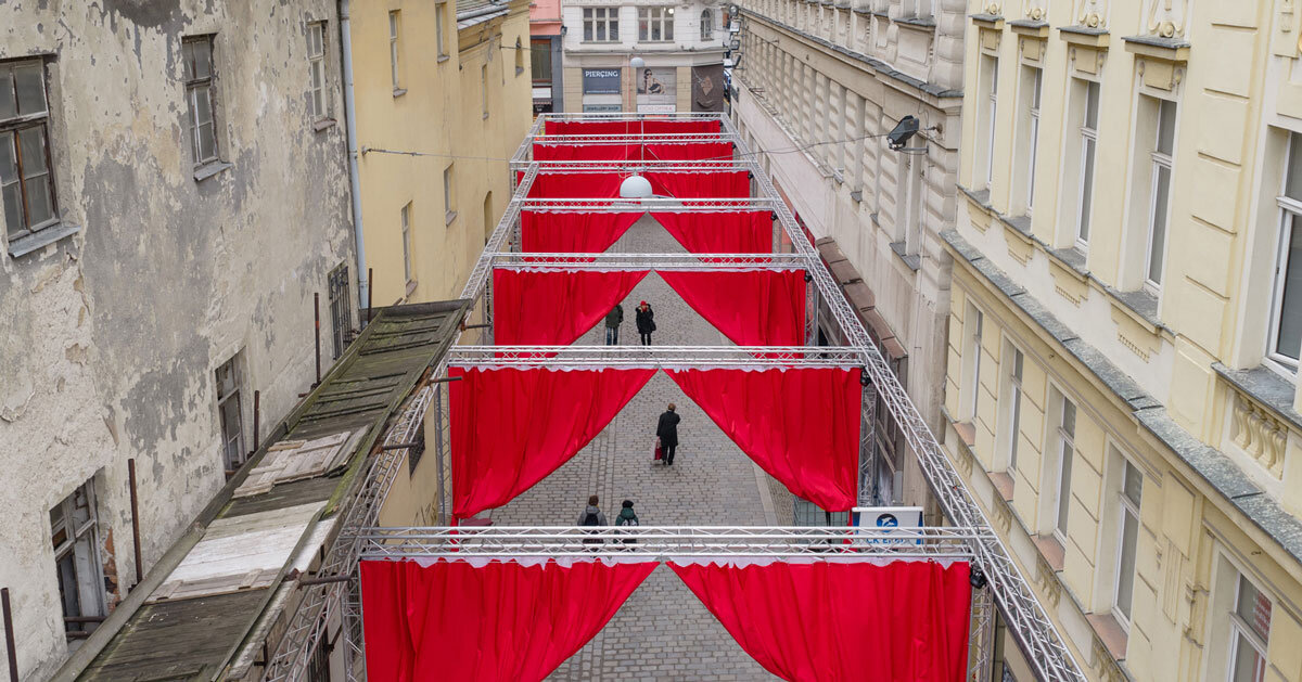 red and white curtains transform czech historic center into christmas installation