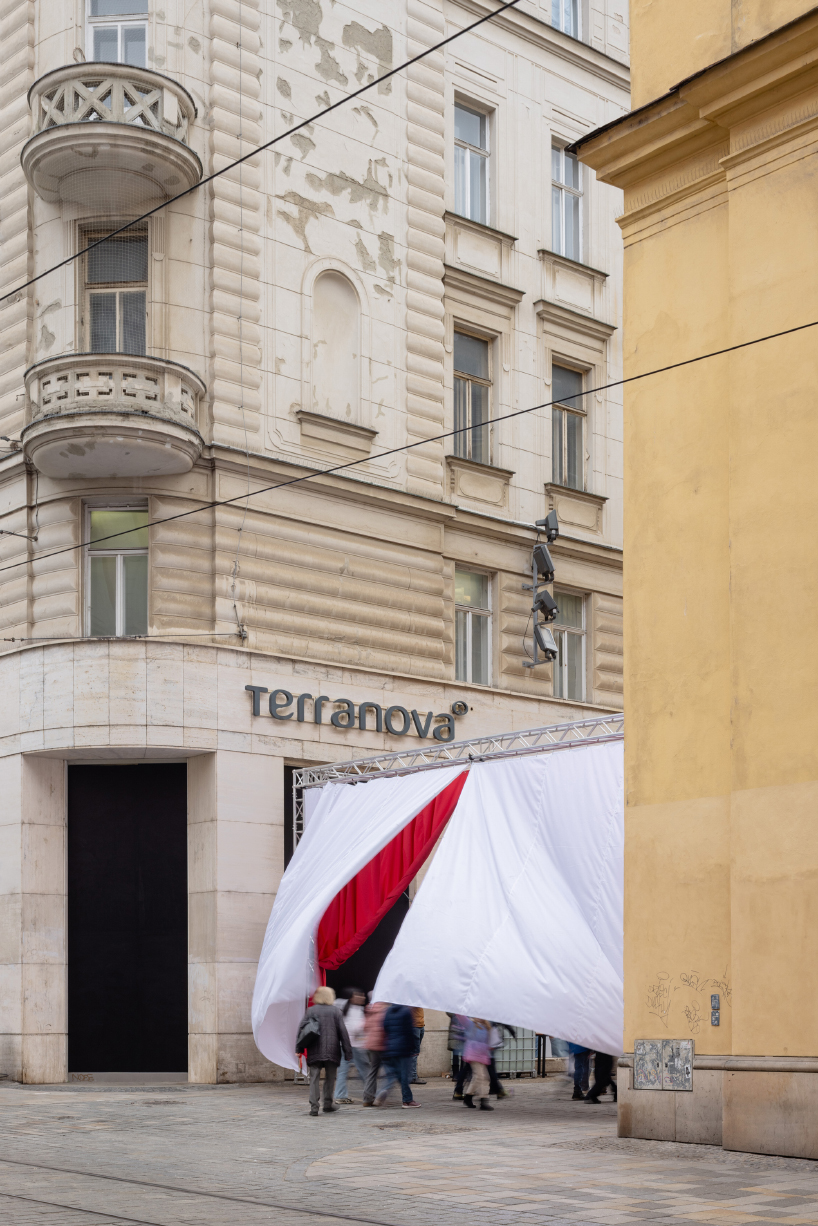 red and white curtains transform czech historic center’s pathways into christmas installation
