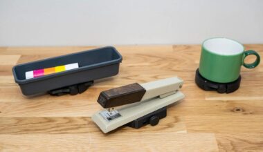 A pencil tray, stapler and coffee mug mounted on wheeled platforms.