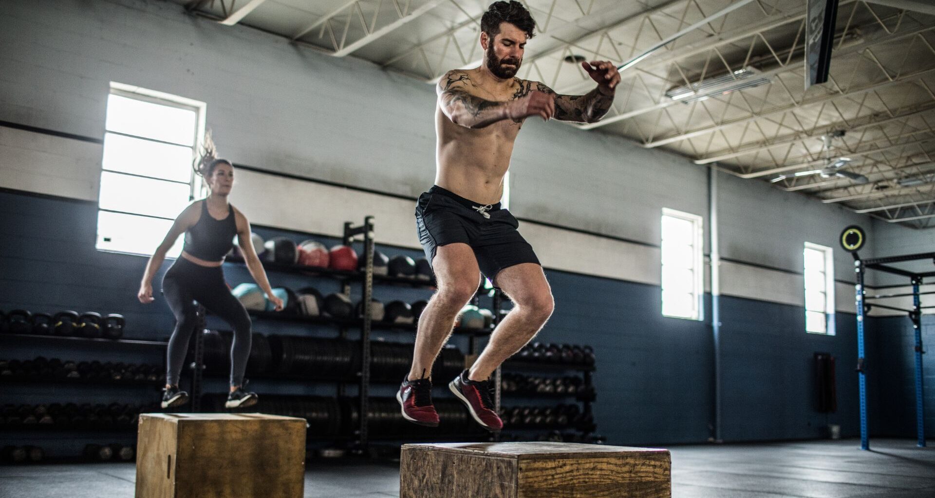 Plyometric exercise box jump being performed by a man and woman