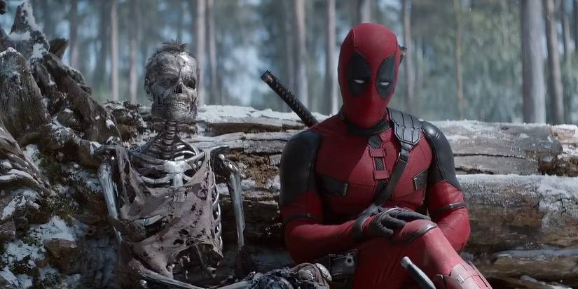 Deadpool sits next to the metal skeleton of Wolverine in a forest in Deadpool & Wolverine.