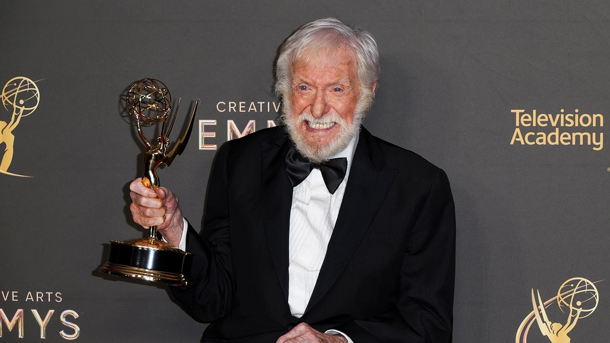 Dick Van Dyke holding an Emmy.