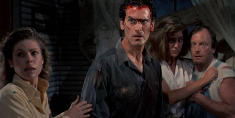 Ash and three others looking ahead with scared expressions in Evil Dead II (1987)