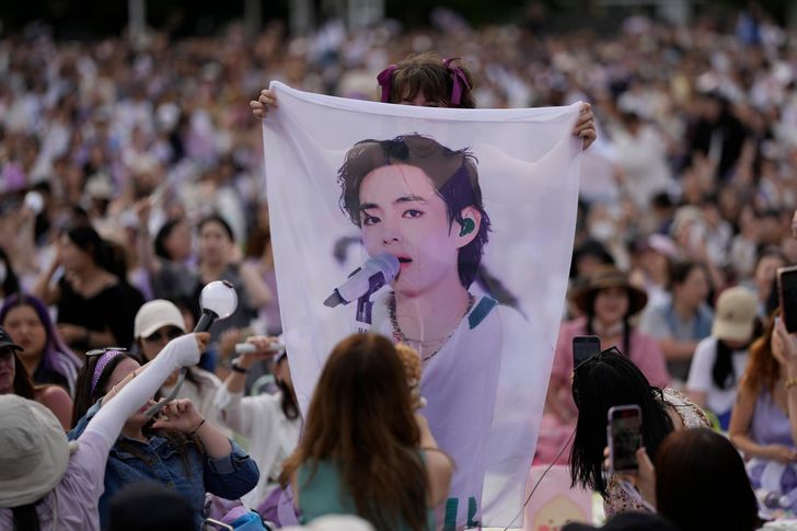 A BTS  fan holds a banner showing an image of V, a member of the group, during an event to celebrate the 10th debut anniversary of K-pop band BTS at a public park near the Han River in Seoul, June 17, 2023. AP-Yonhap