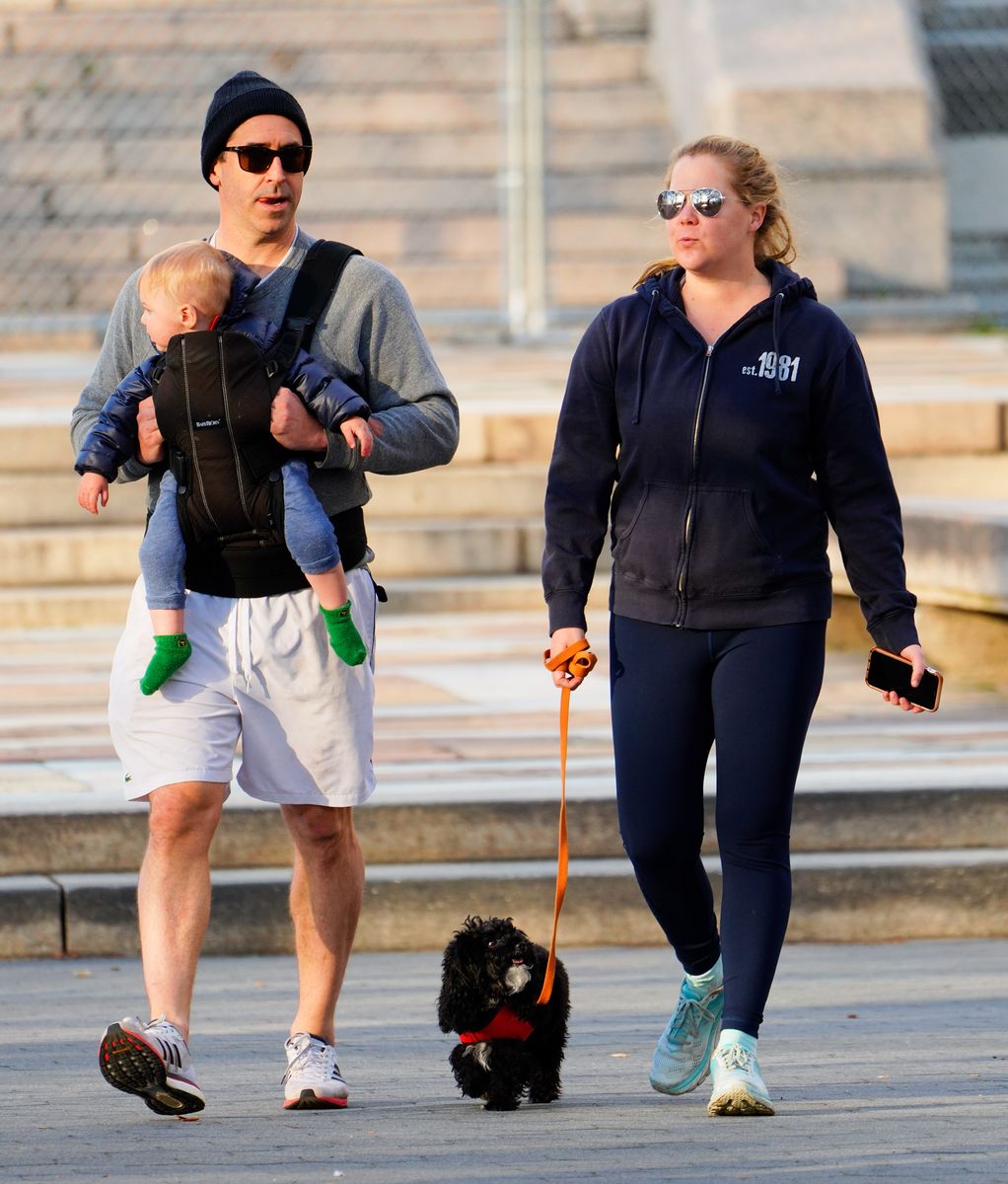 Amy Schumer and husband Chris Fischer take a walk in the park with their son Gene and the family dog in New York City