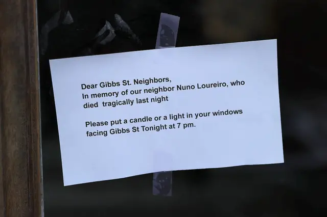 White page on glass door with note addressed to neighbours that asks them to put a candle or light in their windows