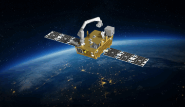 a golden satellite with solar arrays extended, with the limb of Earth in the background