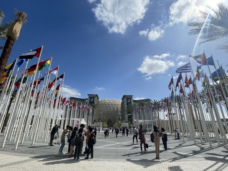 people stand outside building with country flags