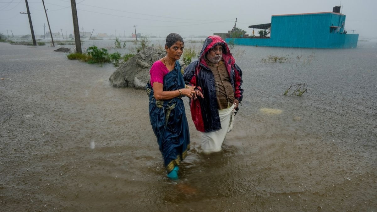 People walk through a flood-affected area amid rainfall due to Cyclone Ditwah in Chennai in December 2025 (Photo: PTI)People walk through a flood-affected area amid rainfall due to Cyclone Ditwah in Chennai in December 2025 (Photo: PTI)