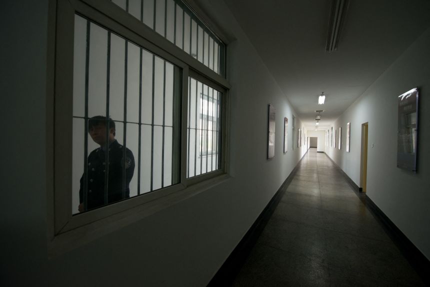 A guard looks through the window of a hallway inside the No. 1 Detention Center during a government guided tour in Beijing on October 25, 2012.