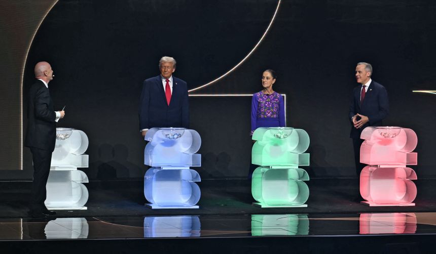 FIFA President Gianni Infantino, left, speaks to US President Donald Trump, Mexican President Claudia Sheinbaum and Canadian Prime Minister Mark Carney during the draw for the 2026 FIFA World Cup at the Kennedy Center on December 5, 2025.