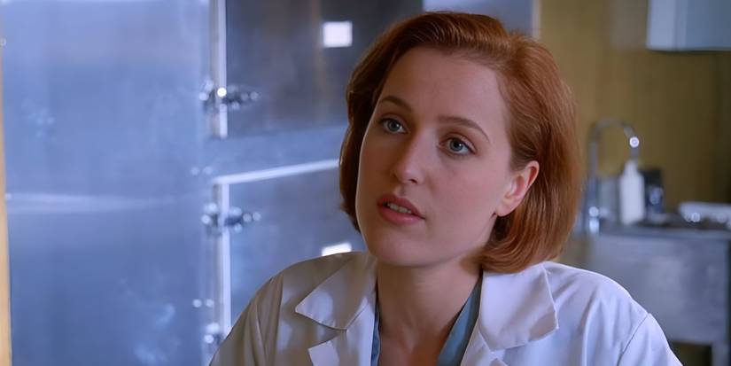Gillian Anderson stands in the morgue dressed in medical garb as Agent Dana Scully in The X-Files.