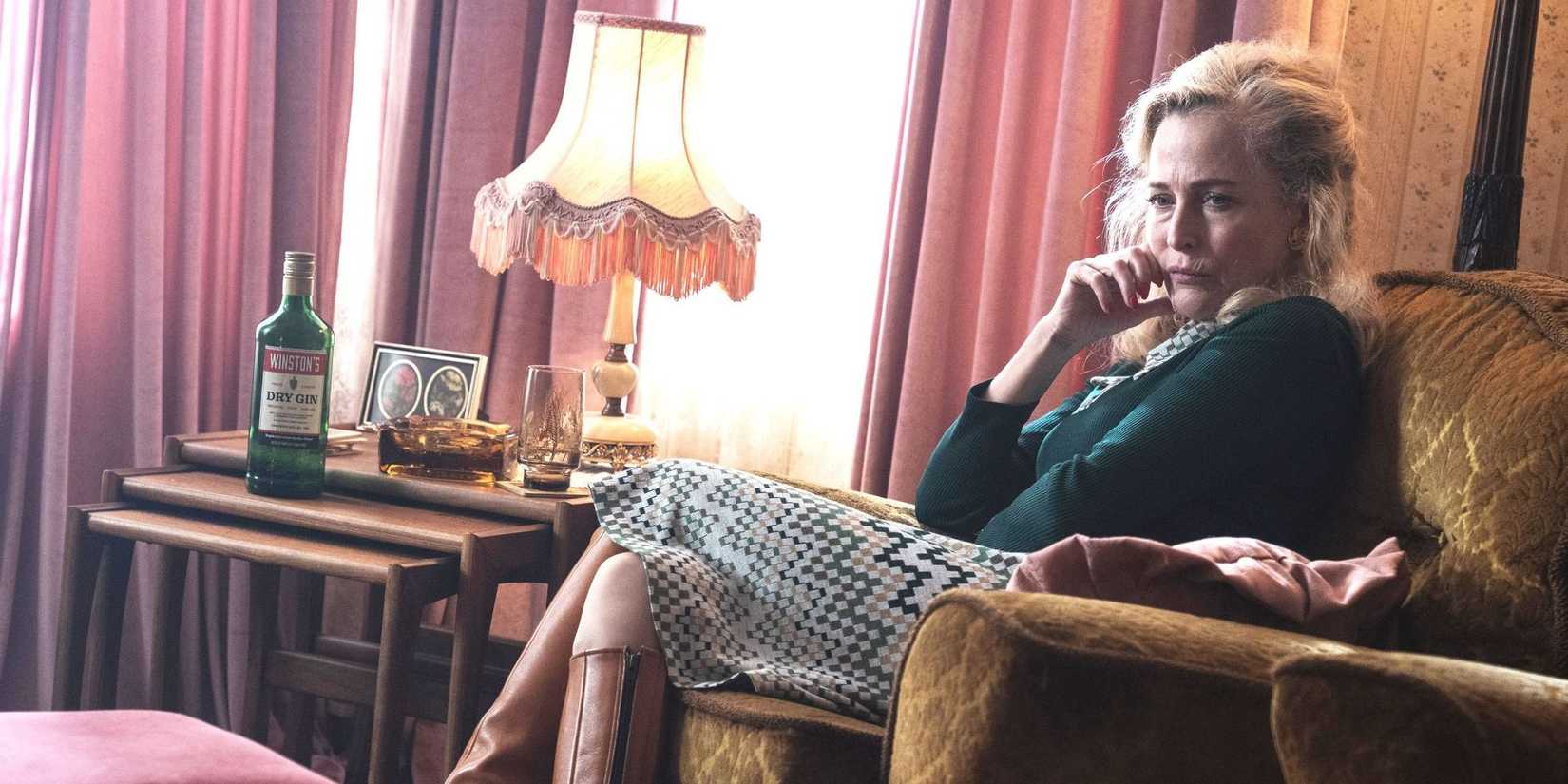 Gillian Anderson sits in an armchair looking deep in thought and sullen in Trespasses.