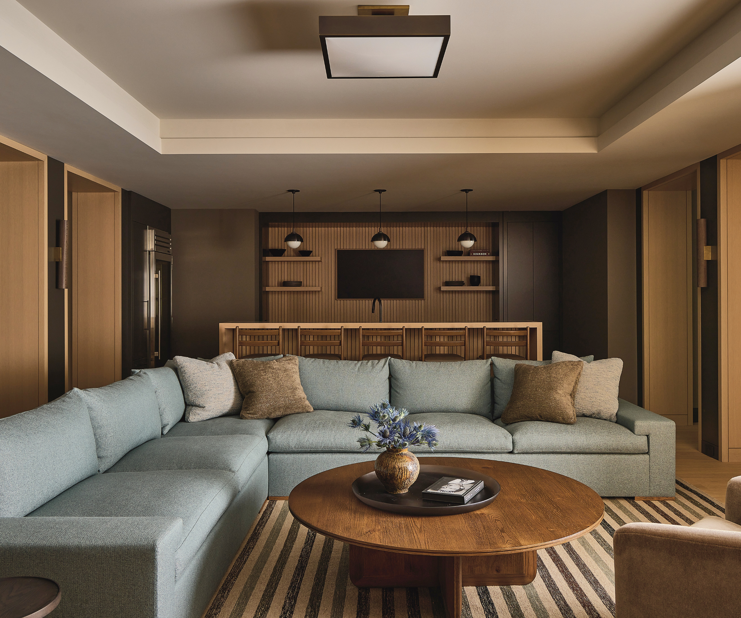 A downstairs media room with a large powder blue sectional.