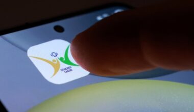 A finger about to tap the Sanchar Saathi app icon on a smartphone screen.